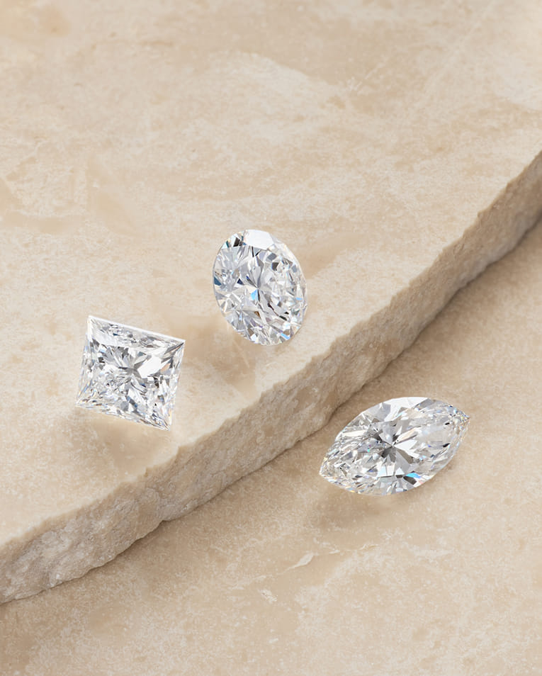 a collection of loose diamonds spread on a stone slab